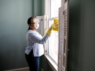 Una proveedora limpiando la ventana de un apartamento
